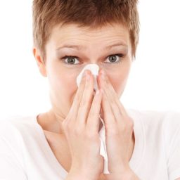 woman holding a tissue to her nose