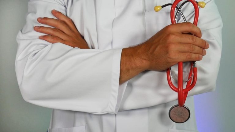 A doctor holding a red stethoscope.