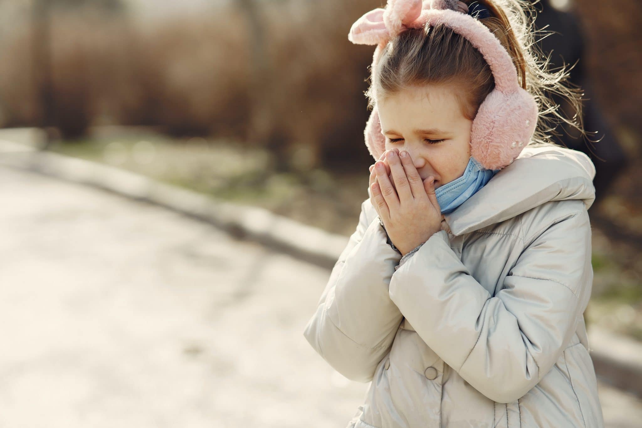 Child covering her nose with her hands.