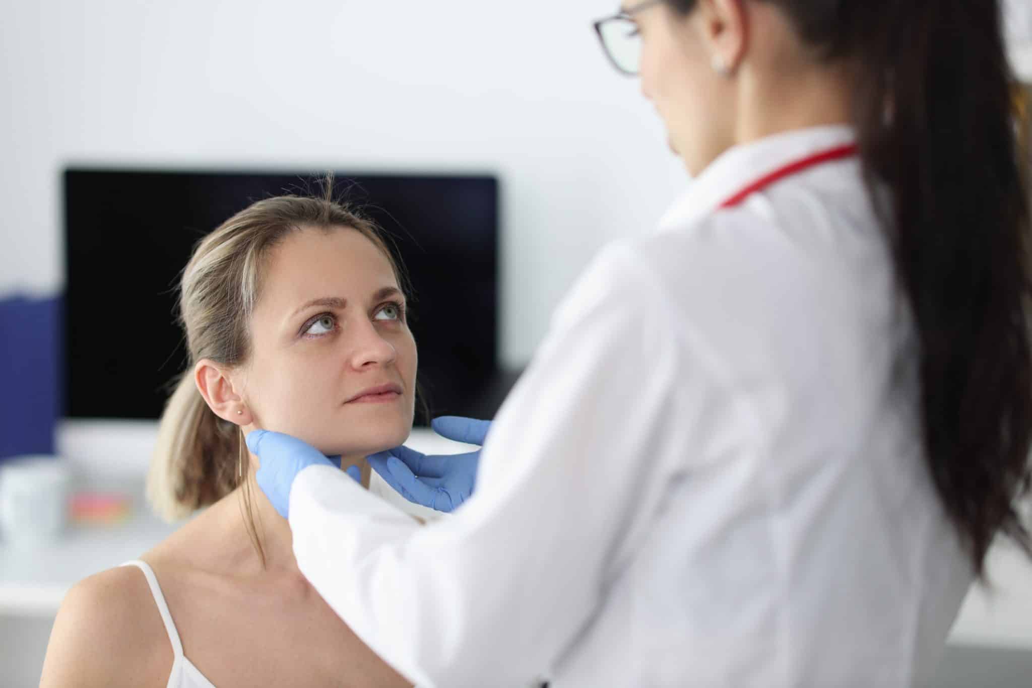 Doctor examining a woman's salivary glands.