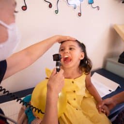 An ENT doctor examining a young girl's throat.