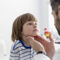 Doctor checking throat of pediatric patient at hospital