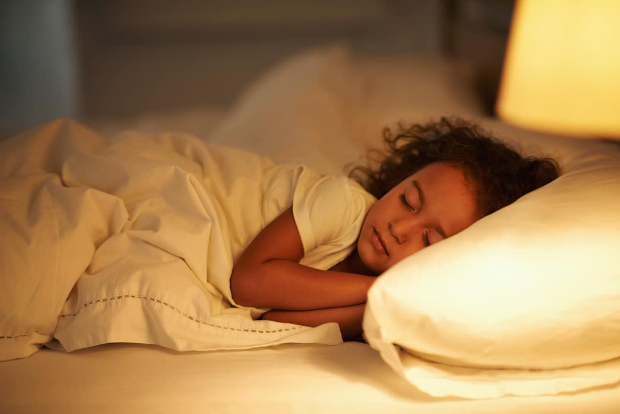Young girl sleeping in bed.