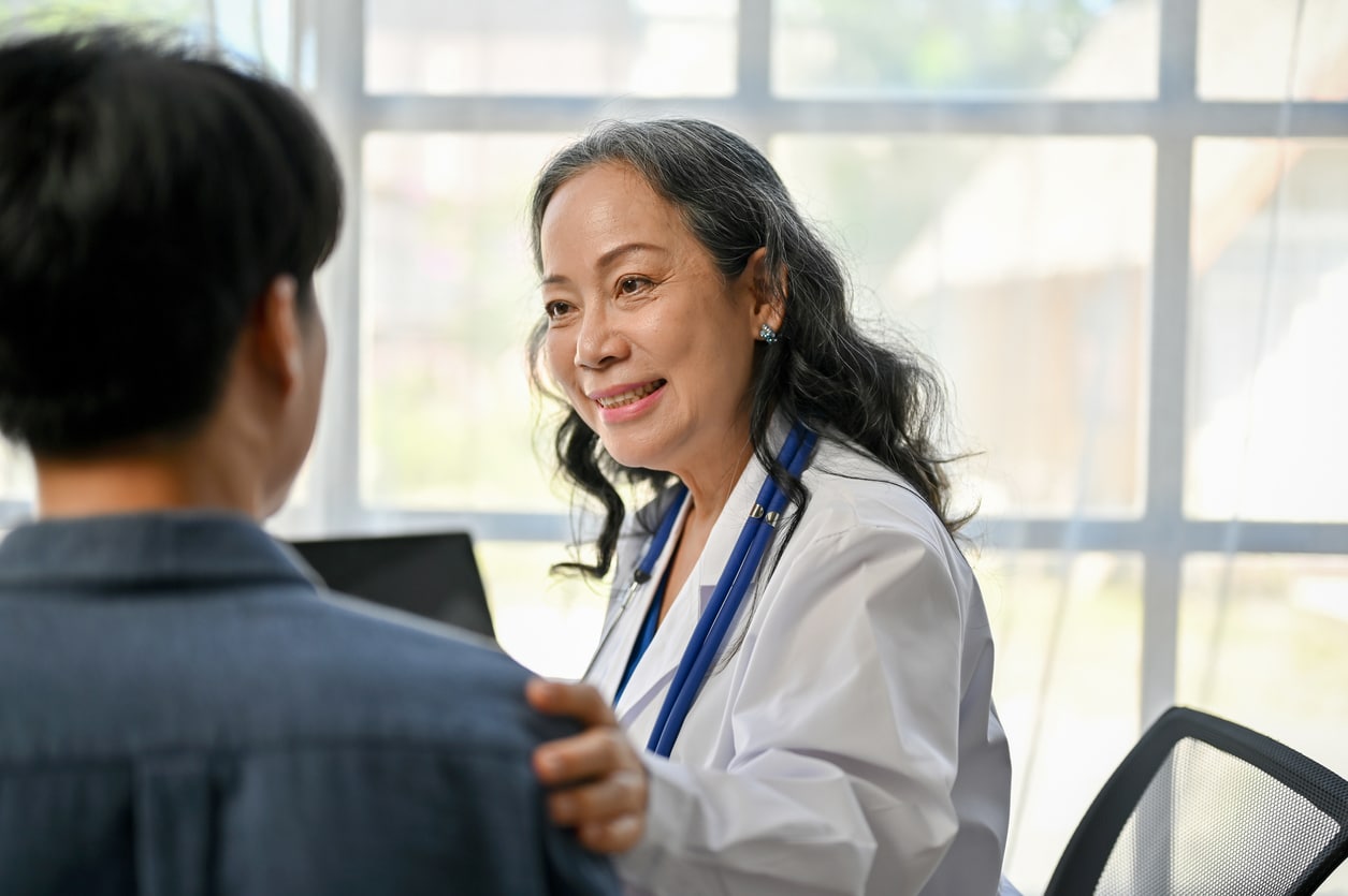 A doctor reassuring a patient during an appointment.