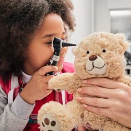 Child at doctor's office plays with teddy bear