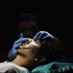 Surgeon touches patient's nose