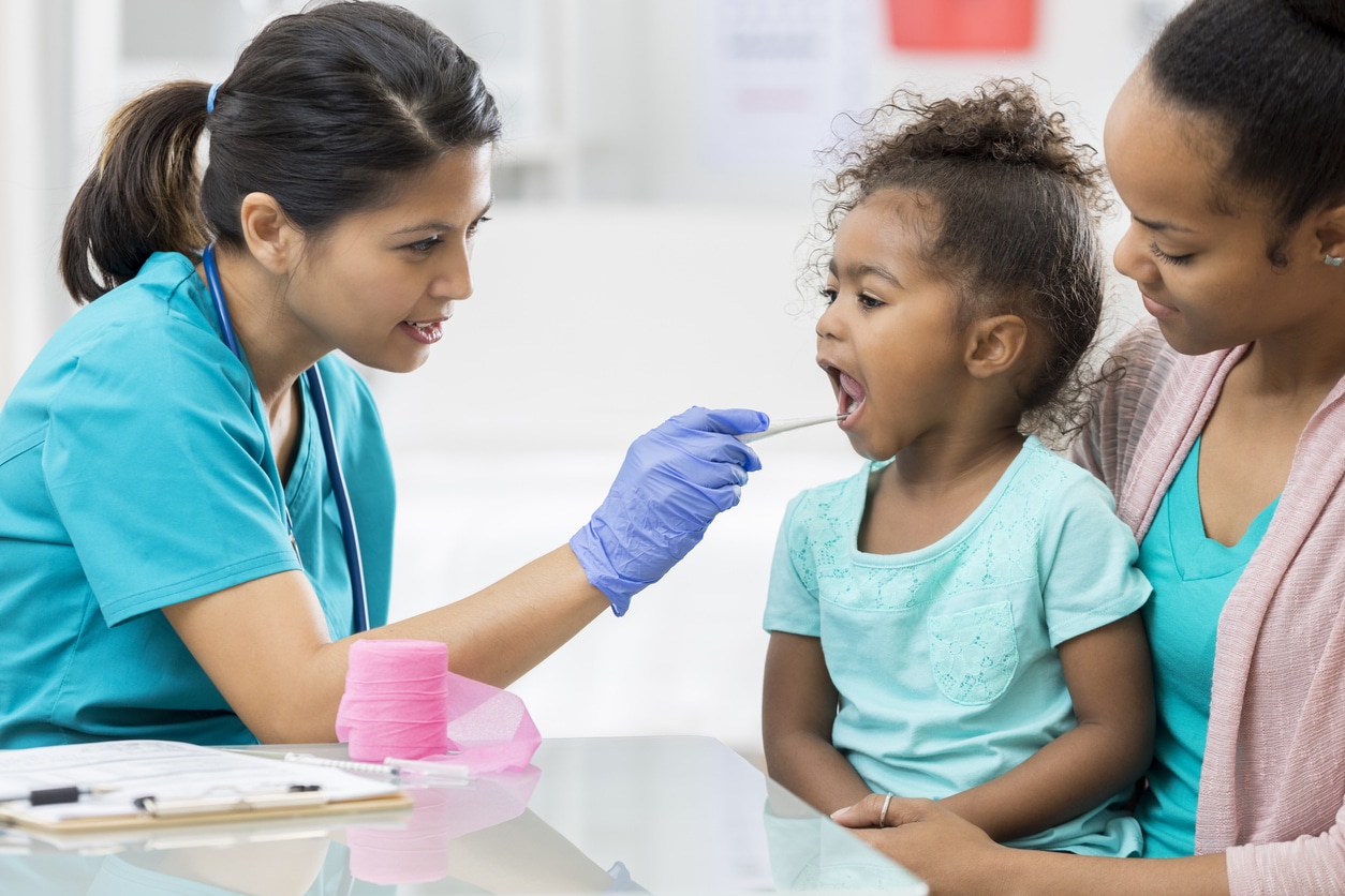 ENT provider examining a young girl's throat.